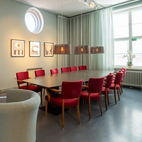 Bild från ett lärarrum med ett stort bord och stolar, lampor och mycket dagsljus som kommer in genom fönstret